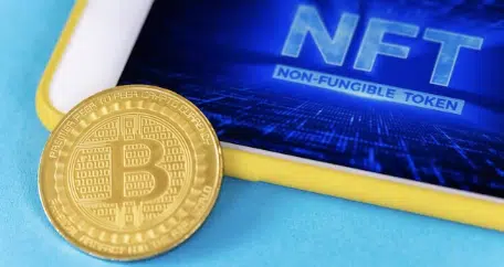 Physical bitcoin gold coin and smartphone with NFT